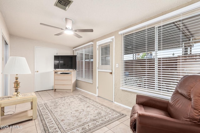 sitting room featuring light tile patterned floors, visible vents, baseboards, and ceiling fan