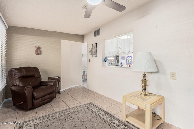 sitting room featuring tile patterned floors, visible vents, and ceiling fan