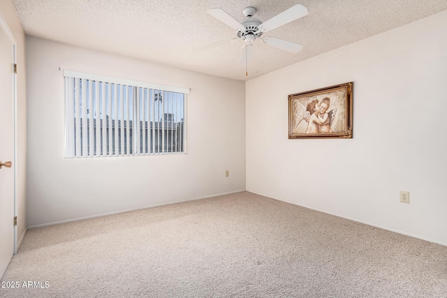 carpeted spare room with a textured ceiling and a ceiling fan