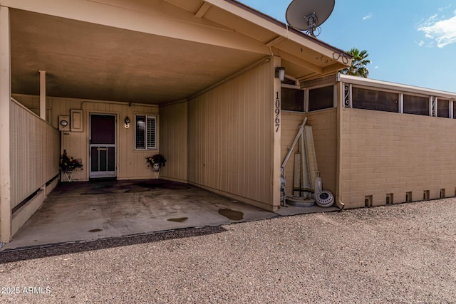 doorway to property with an attached carport