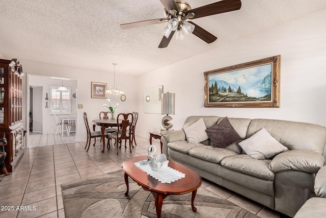 tiled living area featuring ceiling fan with notable chandelier and a textured ceiling