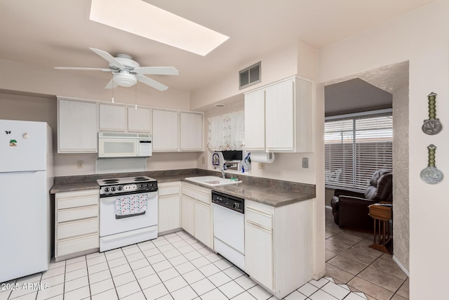 kitchen featuring white appliances, a ceiling fan, visible vents, a sink, and dark countertops