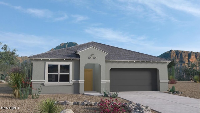 view of front of house featuring a garage, a mountain view, concrete driveway, and stucco siding