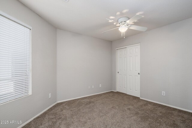 2615 W Silver Streak Way, San Tan Valley, AZ 85144 - unfurnished bedroom with carpet floors, a closet, baseboards, and a ceiling fan