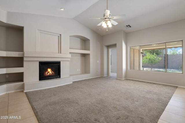 2615 W Silver Streak Way, San Tan Valley, AZ 85144 - unfurnished living room featuring built in shelves, tile patterned floors, a glass covered fireplace, baseboards, and vaulted ceiling