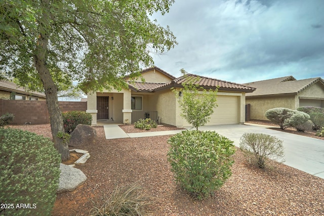 ranch-style house with concrete driveway, stucco siding, an attached garage, fence, and a tiled roof
