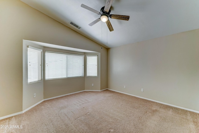 empty room featuring a ceiling fan, light carpet, lofted ceiling, and baseboards