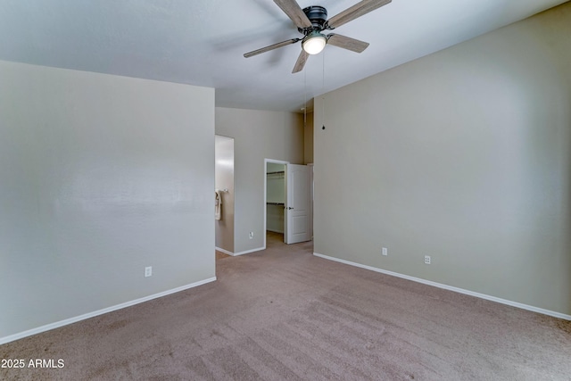 empty room with carpet, a ceiling fan, and baseboards