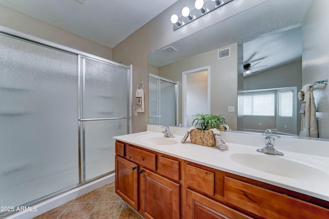 bathroom featuring a shower stall, ceiling fan, double vanity, and tile patterned floors
