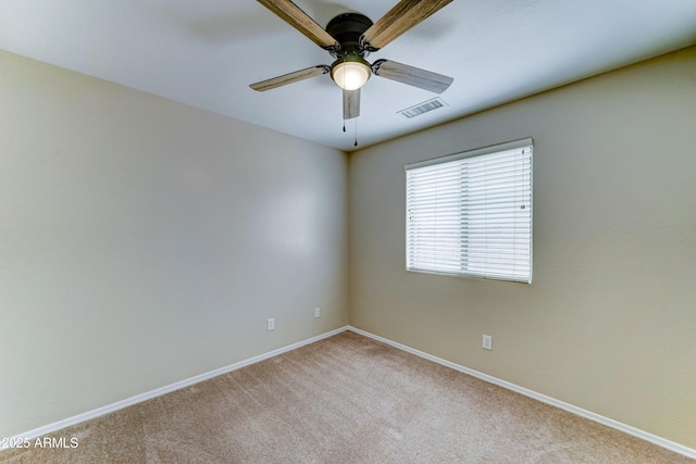 spare room with ceiling fan, carpet, and baseboards