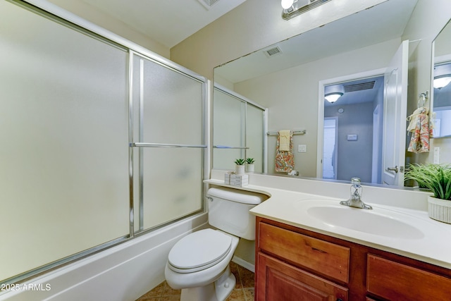 full bath with toilet, bath / shower combo with glass door, vanity, and tile patterned floors
