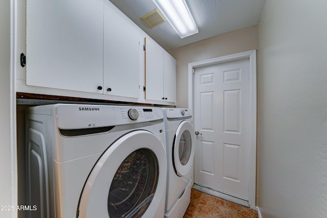 washroom featuring separate washer and dryer, cabinet space, and light tile patterned floors