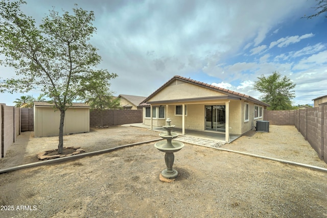 back of house with a patio area, cooling unit, a storage shed, an outdoor structure, and a fenced backyard
