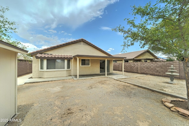back of property with a patio area, a fenced backyard, stucco siding, and a tile roof