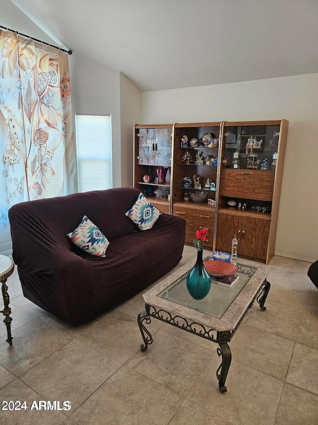 living room featuring tile patterned flooring and lofted ceiling