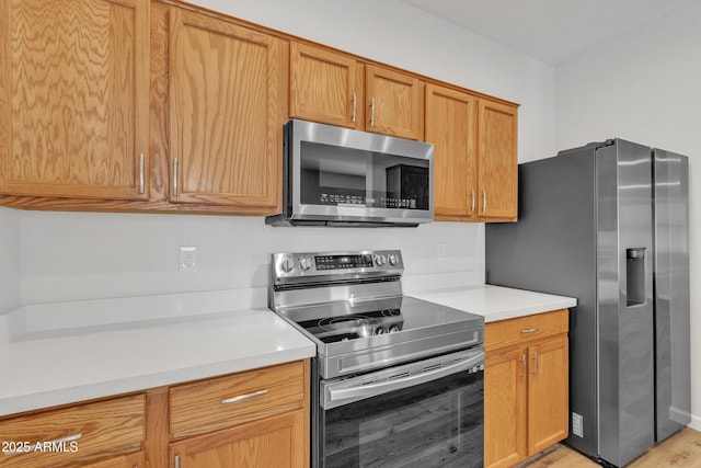 9261 W Sheridan St, Phoenix, AZ 85037 - kitchen with stainless steel appliances, light countertops, and light wood-type flooring