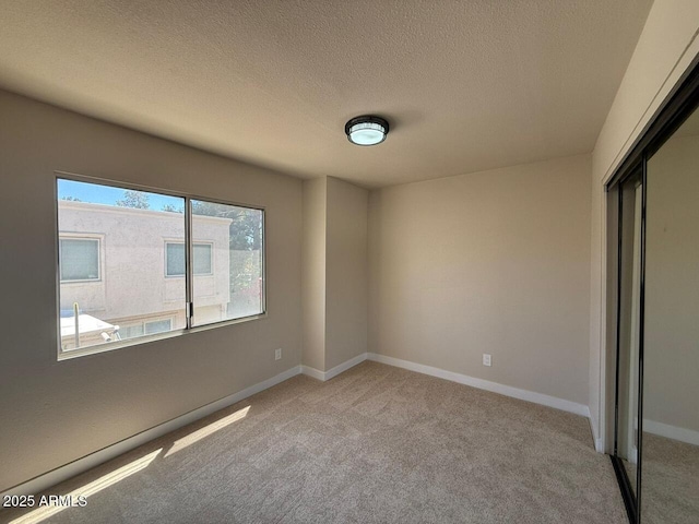 unfurnished bedroom featuring a closet, carpet flooring, baseboards, and a textured ceiling