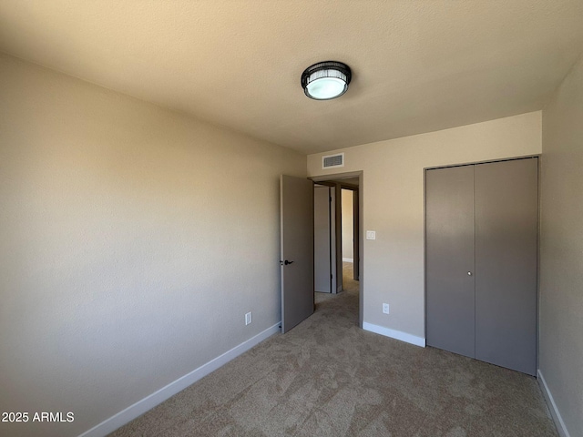 unfurnished bedroom with a closet, carpet, and baseboards