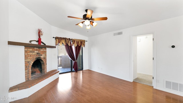 unfurnished living room with lofted ceiling, wood-type flooring, ceiling fan, and a fireplace