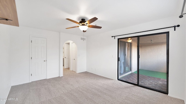 carpeted spare room featuring ceiling fan