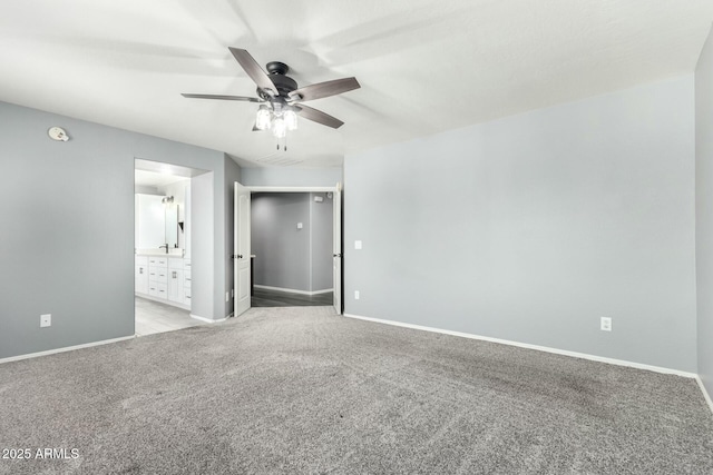 unfurnished bedroom featuring light carpet, ceiling fan, baseboards, and ensuite bathroom