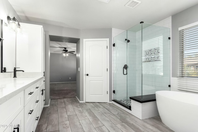 bathroom featuring a stall shower, visible vents, a sink, and double vanity