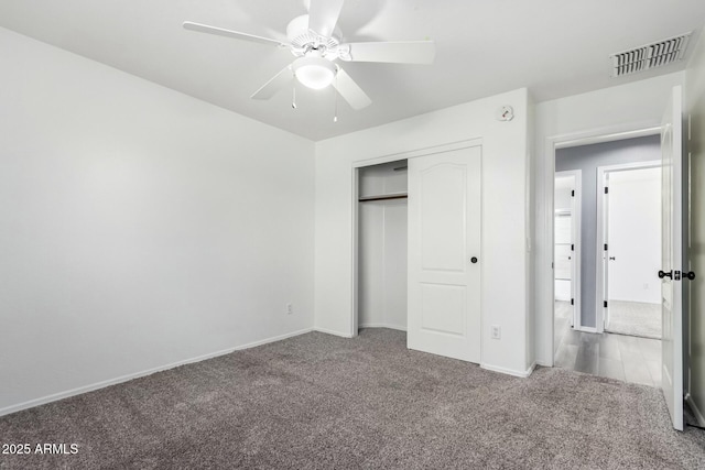 unfurnished bedroom with carpet floors, a closet, visible vents, a ceiling fan, and baseboards