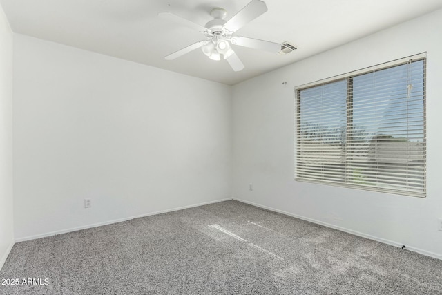 spare room featuring carpet floors, visible vents, baseboards, and a ceiling fan