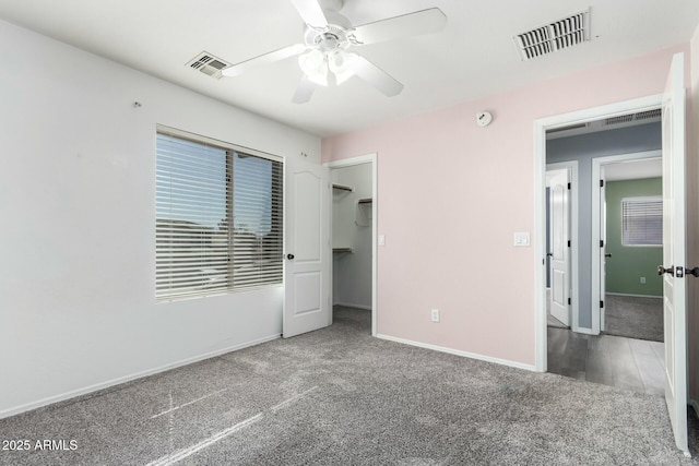 unfurnished bedroom featuring baseboards, visible vents, ceiling fan, and carpet flooring