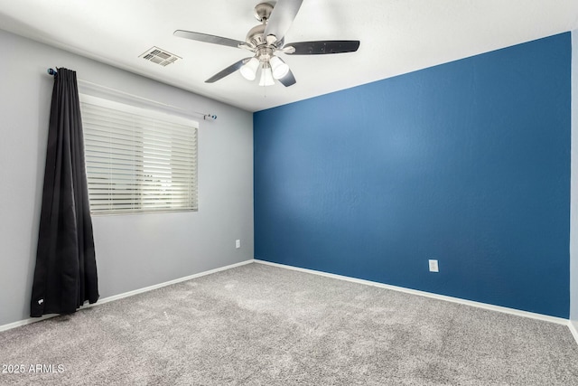 unfurnished room featuring baseboards, carpet, visible vents, and a ceiling fan