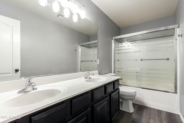 full bathroom featuring toilet, visible vents, a sink, and wood finished floors