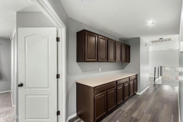 bar featuring wood finished floors, visible vents, and baseboards