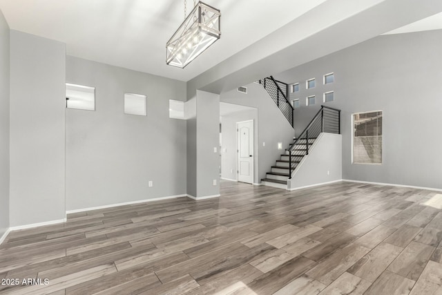 interior space featuring stairs, wood finished floors, visible vents, and baseboards