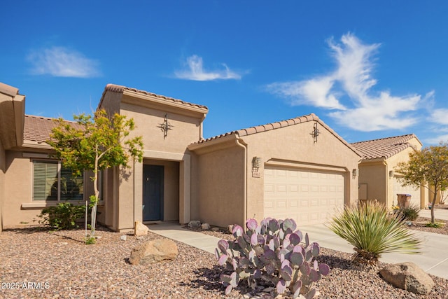 mediterranean / spanish house with concrete driveway, an attached garage, and stucco siding