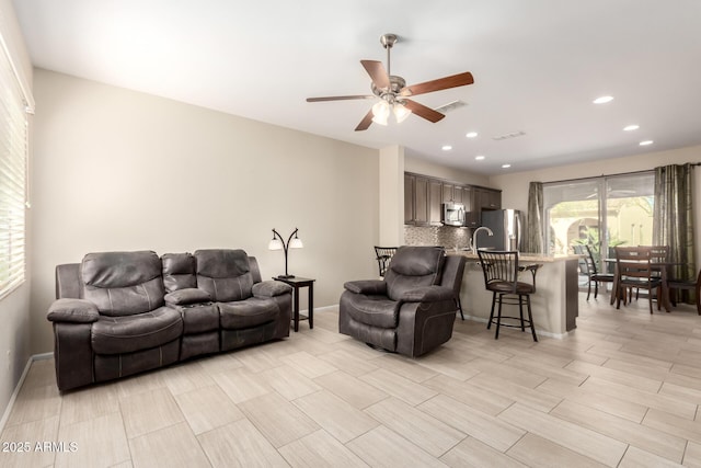 living area with recessed lighting, a ceiling fan, visible vents, and baseboards