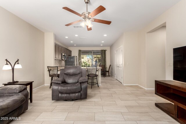 living area featuring recessed lighting, baseboards, and ceiling fan