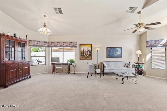 carpeted living room featuring lofted ceiling and ceiling fan with notable chandelier