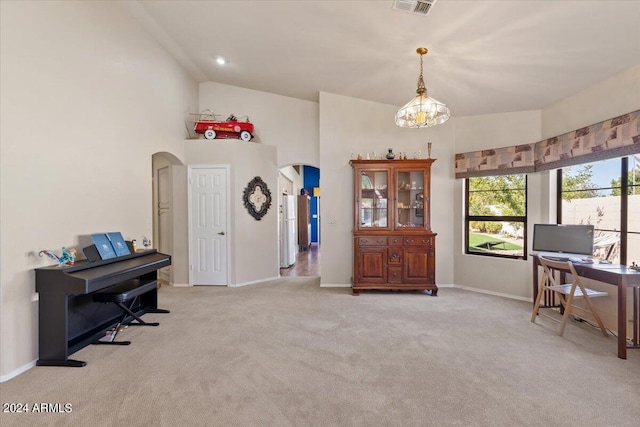 carpeted home office with a chandelier and vaulted ceiling