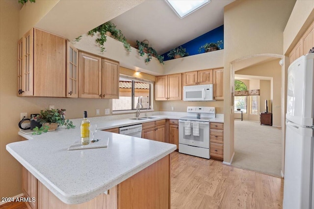 kitchen with white appliances, light brown cabinetry, sink, light wood-type flooring, and kitchen peninsula