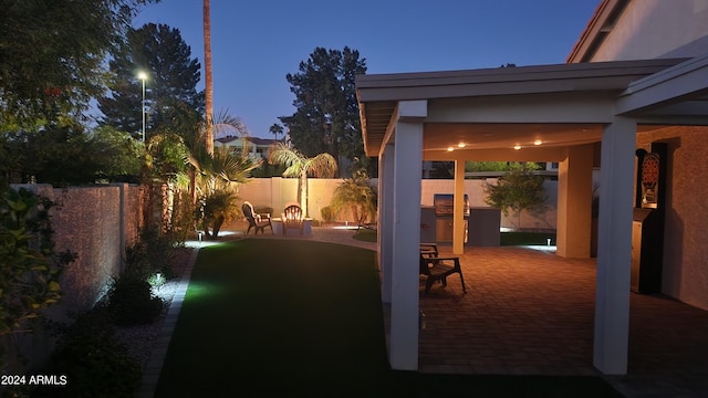 yard at dusk featuring a patio area