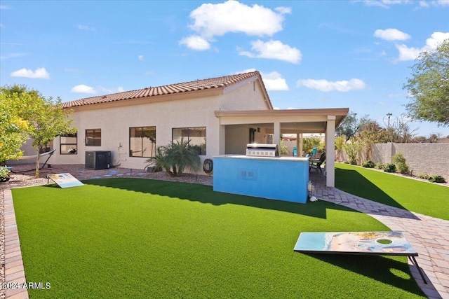 rear view of property featuring a yard, a patio, and central AC unit