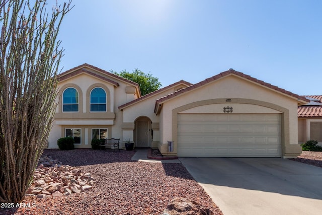 mediterranean / spanish-style house featuring an attached garage, stucco siding, and driveway