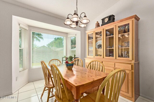 dining space with a chandelier, baseboards, and light tile patterned floors