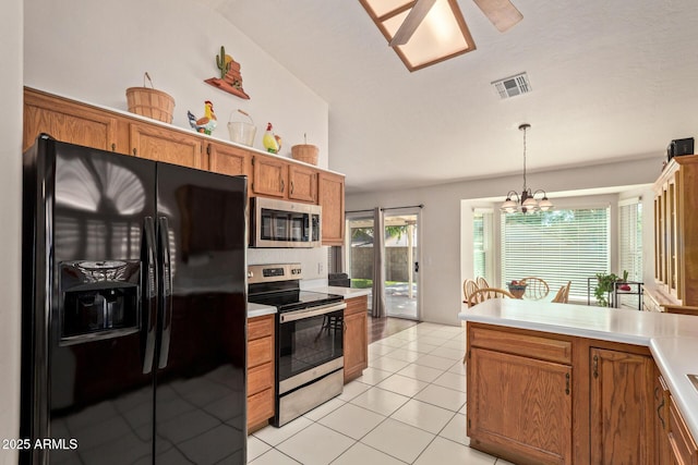 kitchen featuring appliances with stainless steel finishes, brown cabinetry, light countertops, a chandelier, and hanging light fixtures