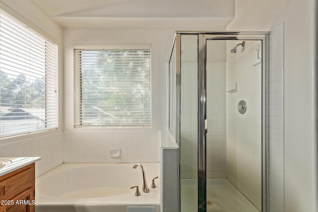 bathroom featuring a bath, plenty of natural light, a stall shower, and vanity