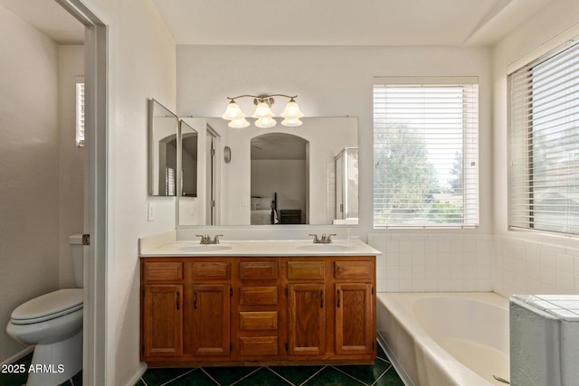 bathroom with tile patterned flooring, healthy amount of natural light, a bath, and double vanity