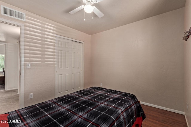 bedroom with baseboards, wood finished floors, a closet, and ceiling fan