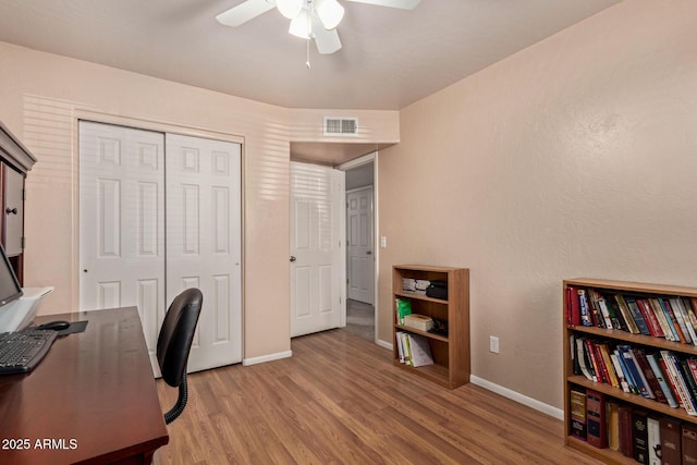 office space featuring ceiling fan, wood finished floors, and baseboards