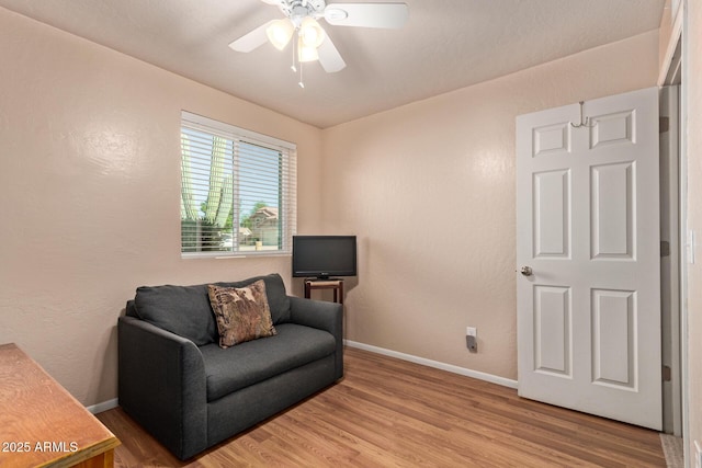 living area with wood finished floors, ceiling fan, and baseboards