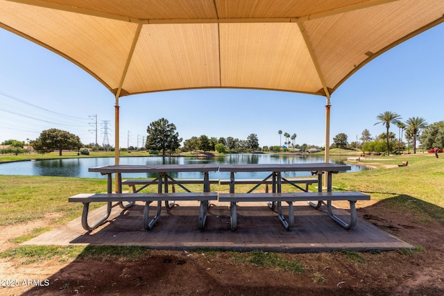 view of community with a yard and a water view